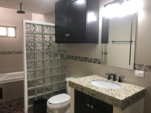 a bathroom with a sink and a toilet and a mirror at Casa Coral in Progreso in Progreso