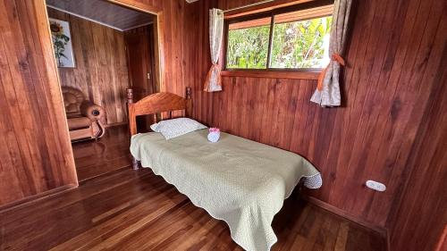 1 dormitorio con 1 cama en una habitación de madera en Campo Azul #2 - Monteverde, en Monteverde