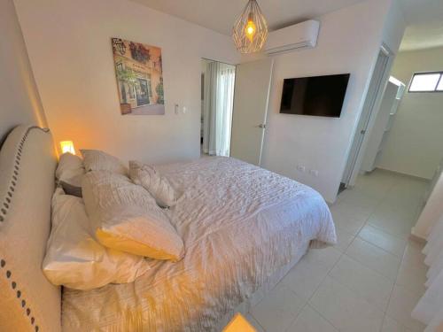 een slaapkamer met een bed met kussens en een televisie bij Luxury Apartment with Great Location 2-A in Matamoros