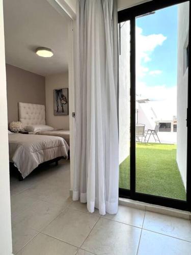 a bedroom with a bed and a sliding glass door at Luxury Apartment with Great Location 2-A in Matamoros