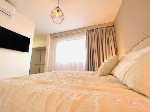 a bedroom with a large bed and a window at Luxury Apartment with Great Location 2-A in Matamoros