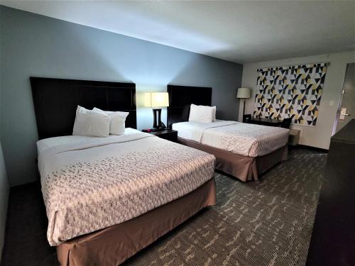 a hotel room with two beds and two lamps at Inn Of Rockwall in Rockwall