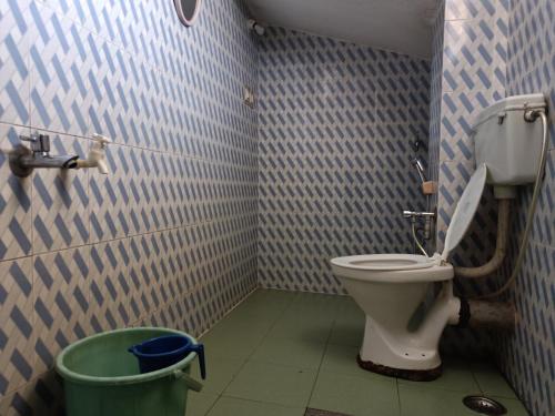 łazienka z toaletą i koszem na śmieci w obiekcie Coorg villas apartment stay w mieście Madikeri