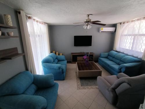 a living room with blue couches and a tv at Casa Epari in Acapulco