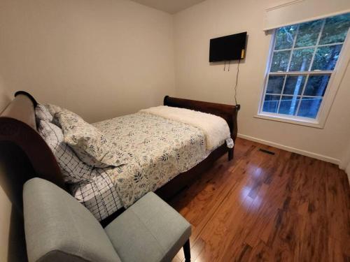 a bedroom with a bed and a couch and a television at 11. Spacious Lakeview home in Guntersville in Guntersville