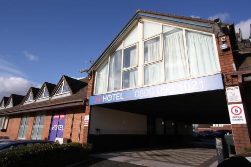 a hotel with a sign on the side of a building at 247Hotel in Oldham