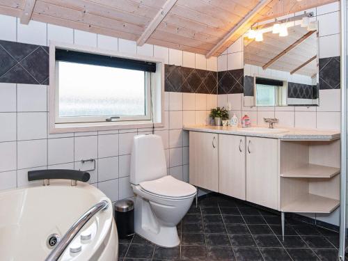 a bathroom with a toilet and a sink and a tub at Three-Bedroom Holiday home in Hemmet 55 in Hemmet