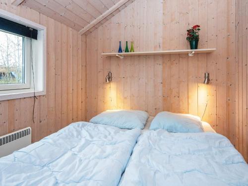 a bedroom with two beds in a wooden wall at Luxury Spa Retreat by Bork - By Traum Ferienwohnungen in Hemmet