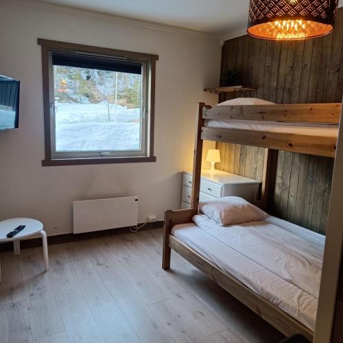 a bedroom with a bunk bed and a window at BUDGET Kvamseter Lodge in Eikjedalen