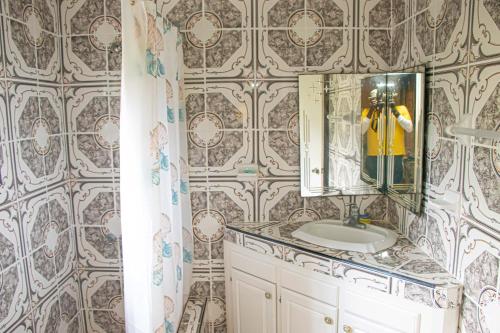 a bathroom with a sink and a mirror at Charlie's Cottages in Negril