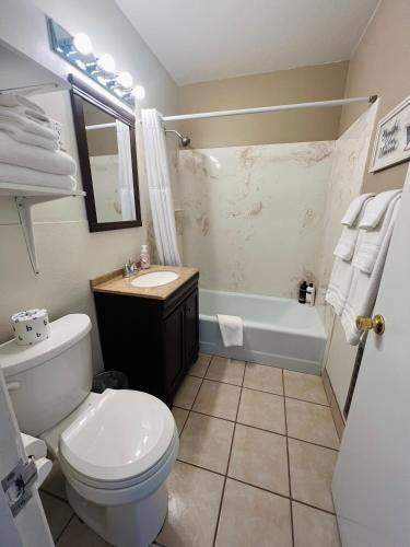 a bathroom with a toilet and a sink and a tub at Lake Powell Motel & Apartments in Page