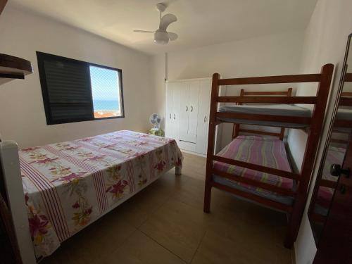 een slaapkamer met een stapelbed en een ladder bij Apartamento cidade ocian Praia Grande in Praia Grande