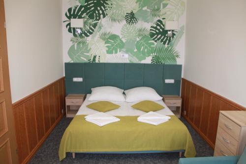 a bedroom with a bed with two pillows on it at Hotel Zielony & OW Borowik & Pensjonat Manhattan - Centrum Rekreacji i Wypoczynku GASTROTUR in Turawa