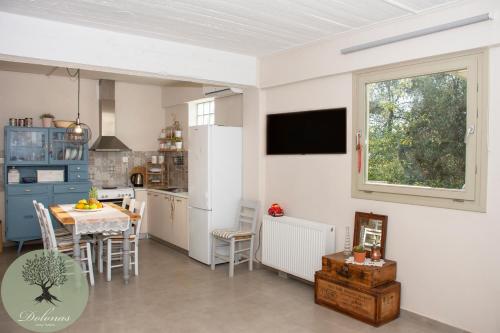 een keuken en eetkamer met een tafel en een raam bij DOLONAS Cosy House 