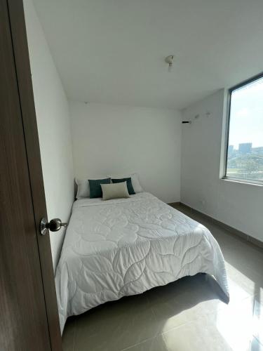 - une chambre blanche avec un lit et une fenêtre dans l'établissement apartamento barranquilla villa campestre!, à Puerto Colombia
