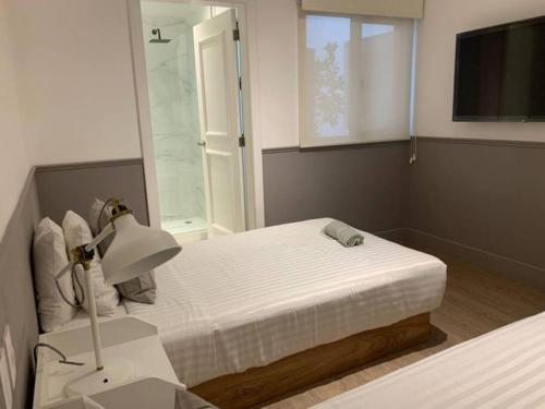a bedroom with a bed with a lamp and a mirror at Departamentos cerca de Reforma y Monumento a la Revolución in Mexico City