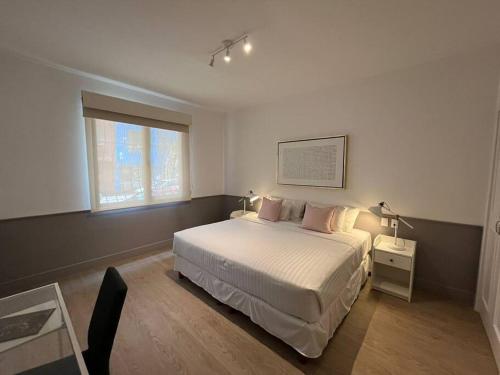 a bedroom with a white bed and a window at Departamentos cerca de Reforma y Monumento a la Revolución in Mexico City