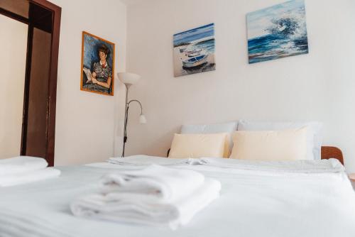 a white bed in a bedroom with pictures on the wall at Heart City Apartment in Ohrid