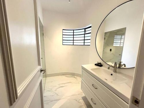 a white bathroom with a mirror and a sink at Departamentos cerca de Reforma y Monumento a la Revolución in Mexico City