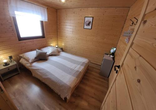 1 dormitorio con 1 cama en una habitación de madera en Siedlisko Wataha en Wołkowyja