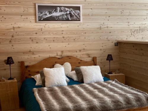 a bedroom with a bed with a wooden wall at LAPRESKI, Appartement 4 étoiles, atmosphère chaleureuse entre Annecy et Aravis in Thônes