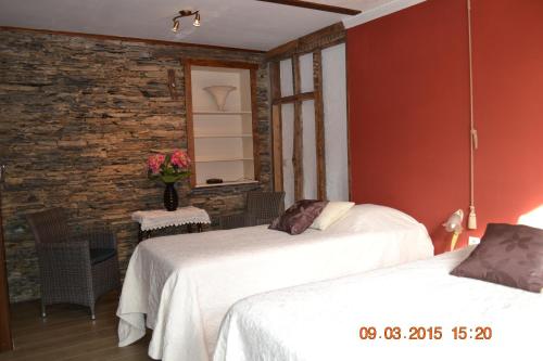 two beds in a room with a brick wall at Auberge Au Naturel des Ardennes in Rochehaut