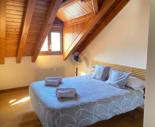 - une chambre avec un grand lit bleu et des plafonds en bois dans l'établissement Cálido piso -BONAVISTA- ¡IDEAL PARA TI Y LOS TUYOS !, à Sort