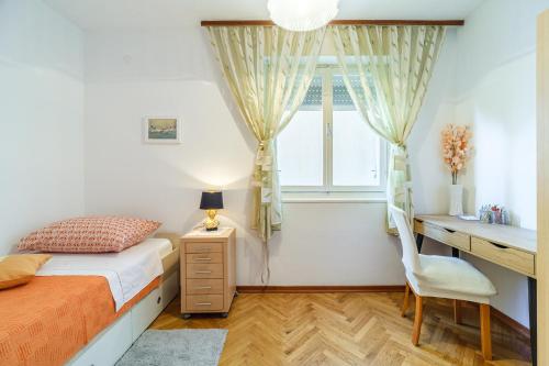 a bedroom with a bed and a desk and a window at Apartment 123 for you in Split