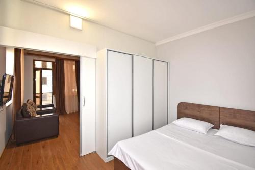 a bedroom with a white bed with a wooden headboard at 74/3New building in the center of the capital in Yerevan