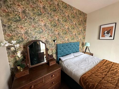 a bedroom with a bed and a mirror on a dresser at Central Apartment - Classic in Blairgowrie