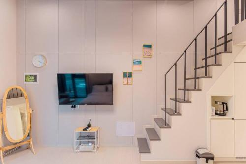 ein Wohnzimmer mit einer Treppe und einem TV in der Unterkunft The Castle Ocean Marina Double Suite in Yeosu