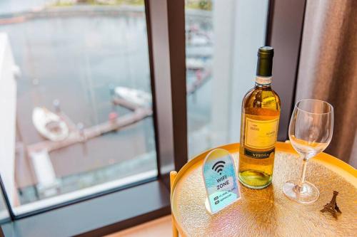a bottle of wine sitting on a table with a glass at The Castle Ocean Marina Double Suite in Yeosu
