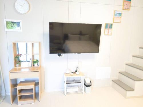 a living room with a flat screen tv on a wall at The Castle Ocean Marina Double Suite in Yeosu