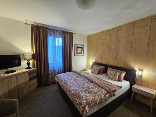 a hotel room with a bed and a television at Penzión Villa Breza in Vysoke Tatry - Novy Smokovec