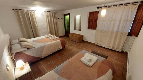 1 dormitorio con 2 camas y suelo de baldosa en Rural Kairós "Un espacio con alma" en Siete Aguas