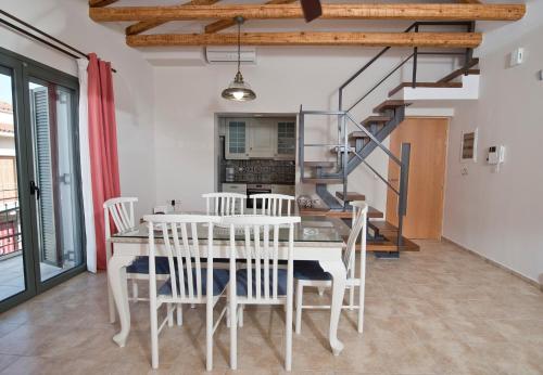une salle à manger avec une table et des chaises blanches dans l'établissement Mare e Pietra, à Monemvasia