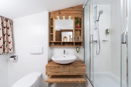 La salle de bains est pourvue d'un lavabo et d'une douche. dans l'établissement MONDI Bellevue Alm Gastein, à Bad Gastein