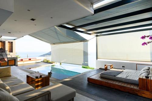 a living room with a large window and a swimming pool at Athens riviera beach villa in Anavyssos