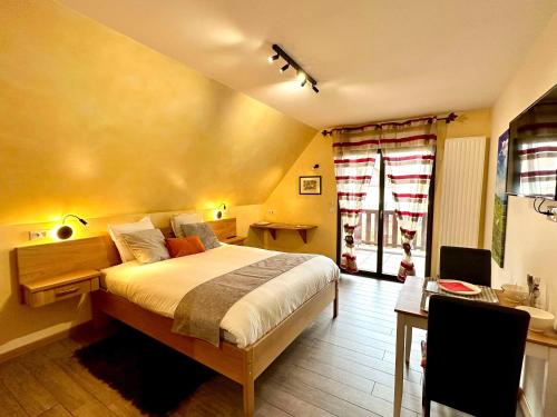 een slaapkamer met een groot bed en een bureau bij Les Chambres Du Vignoble in Ammerschwihr
