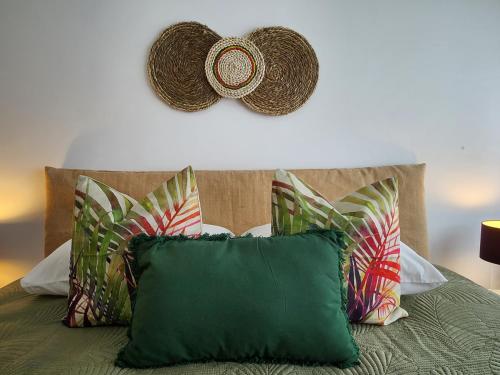 Una cama con almohadas y un sombrero en la pared en Cozy Island Apartment RAAL 1096 - Free Parking en Ponta Delgada