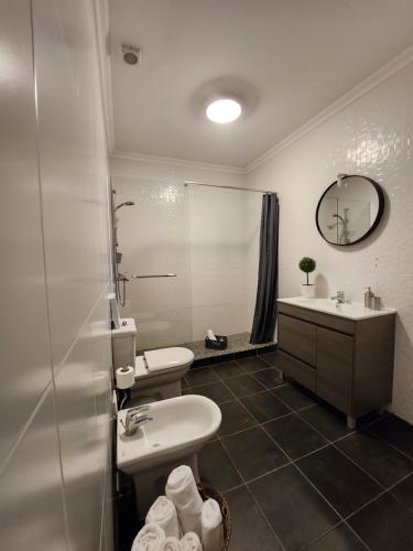 y baño con 2 lavabos, aseo y espejo. en Cozy Island Apartment RAAL 1096 - Free Parking en Ponta Delgada