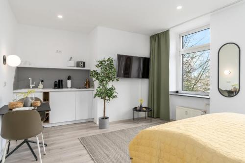 1 Schlafzimmer mit einem gelben Bett und einer Küche in der Unterkunft BRIGHT Dortmund City Center in Dortmund