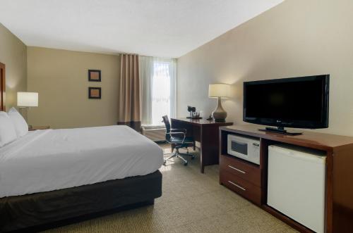 a hotel room with a bed and a flat screen tv at Comfort Inn Blacksburg University Area in Blacksburg