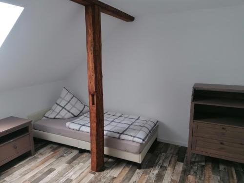 a bed in a room with a wooden bed frame at Ferienwohnung IV Sarrebriese in Bottmersdorf