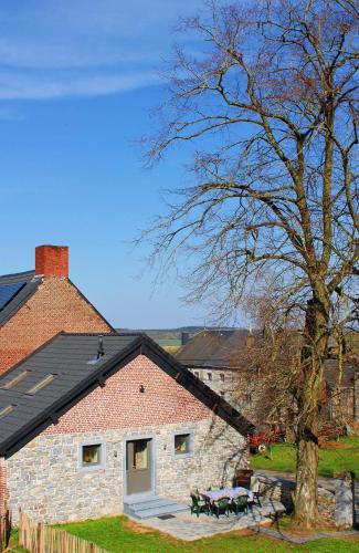 a brick house with a picnic table in front of it at Au chant du coq in Wancennes