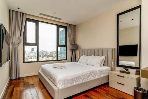 a bedroom with a white bed and large windows at The Rixx Spectacular Apartment @ Opera House-Hyatt in Ho Chi Minh City
