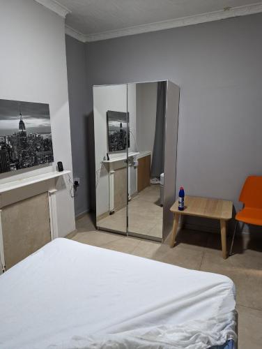 a bedroom with a white bed and a mirror at Court Road House in Cardiff