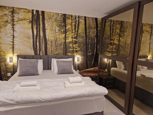 - une chambre dotée d'un grand lit et d'une fresque murale représentant la forêt dans l'établissement KORZO SUITES ST. JULIAN`S, à San Ġiljan