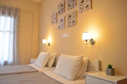 1 dormitorio con 1 cama con sábanas y almohadas blancas en Αndreas Studios, en Ýpsos