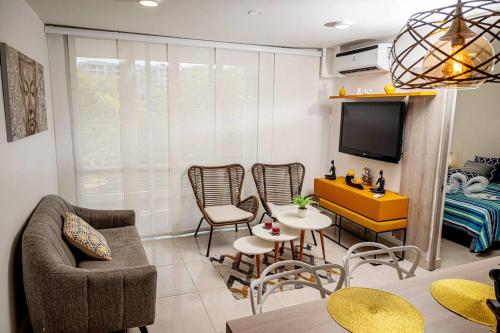 a living room with a couch and chairs and a tv at Marquis Enclave, Condo With Pool Access and More in Ricaurte